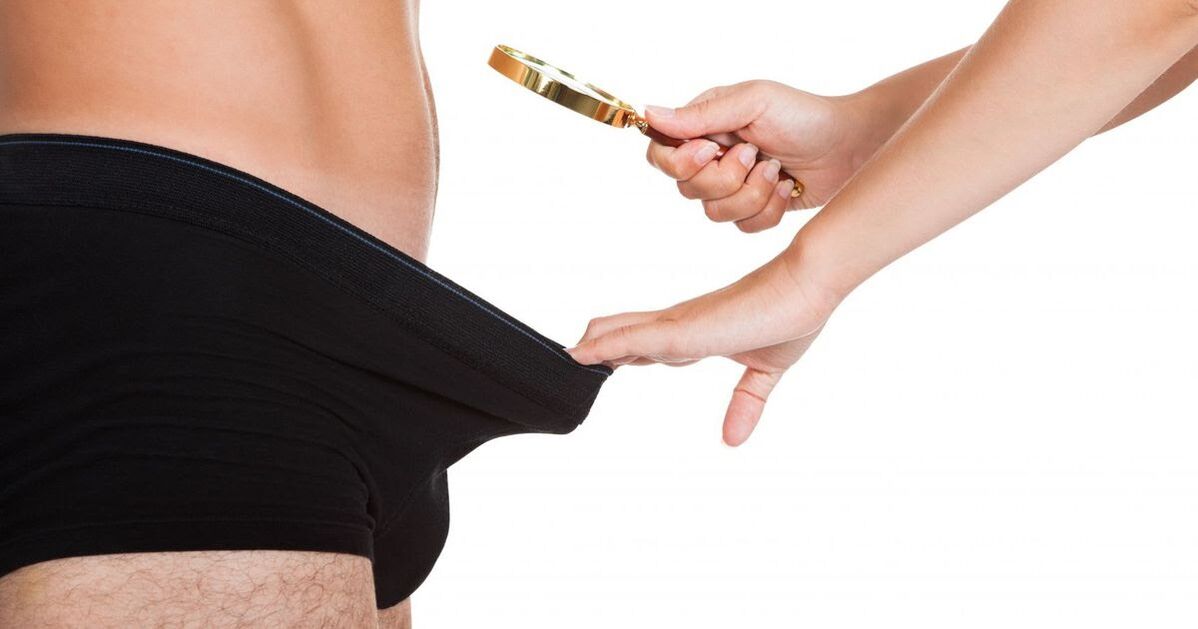 Ein Mädchen blickt durch eine Lupe auf einen kleinen Penis
